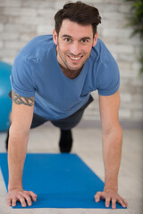 happy handsome man doing push ups at home