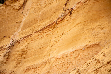 Textural sand, with  relief surface, multi-colored layers and different in size of granules, in outdoor sand career, after mining ore and sand for construction.