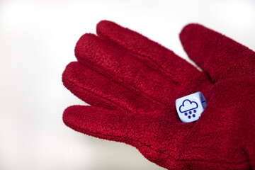 gloved hand holding a dice representing snow