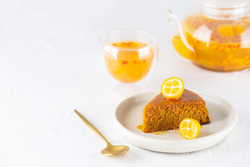 A piece of homemade vegan sea buckthorn pie, manna with orange, garnished with kumquat and tea. Horizontal orientation, copy space.