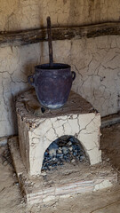 A fireplace in a medieval house with a pot