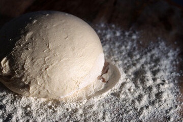 Fresh sourdough on a table. Dough ball on wooden table. Top view photo.
