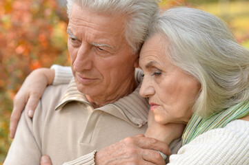 Close up portrait of senior couple in autumn park hugging