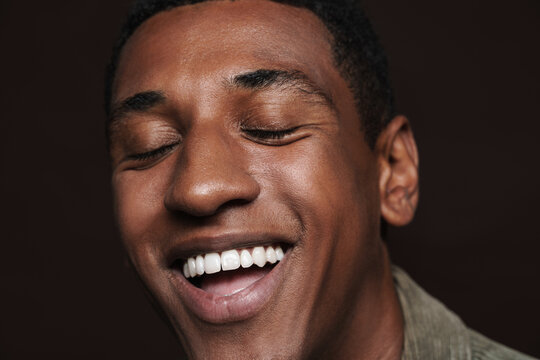 Young black man laughing with his eyes closed