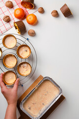 Distribution of dough into molds for baking orange and carrot cake. The recipe is step-by-step. Top view. Girl hands