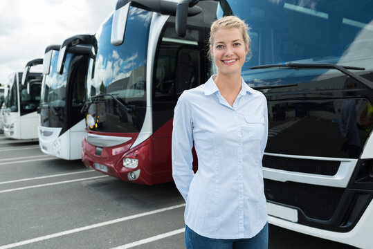 female bus operator posing in front of buses