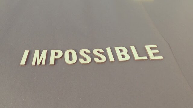 Nothing is impossible, the word itself says I am possible. Man hand separating I M letter from impossible to say possible. Success and challenge concept. Retro style image.