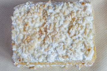 Overhead view of chopped almonds au gratin with cream and meringue. Traditional sweet desserts and textures.