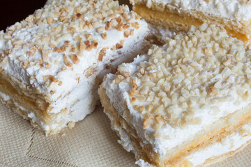 Several individual servings of Costrada on a platter. Traditional sweet puff pastry dessert, filled with cream and meringue and covered with chopped and au gratin almonds.