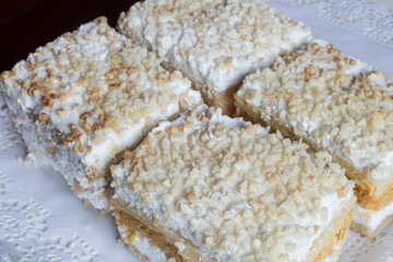 Millefeuille made with puff pastry and filled with pastry cream and meringue. The dessert is topped with toasted chopped almonds and icing sugar. Simple and traditional sweet.
