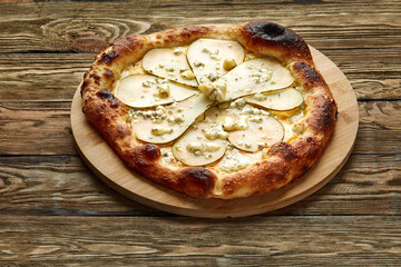 pizza with pear and gorgonzola on a wooden background