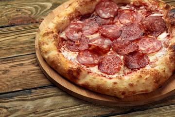 Pepperoni pizza on rustic, vintage style wood background. Top view