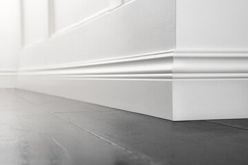 Close up of decorative, moulding white baseboard corner in empty room with copy space - obrazy, fototapety, plakaty