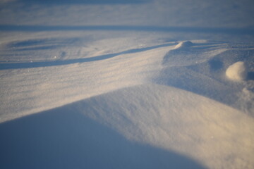 Snowy landscapes and snow close-up in sunbeams. Grass and objects in the snow.