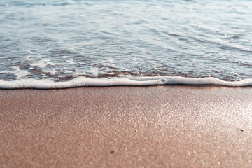 Smooth sandy at the beach and beautiful wave in background. Soft wave blue ocen and sandy beach. Small waves lapped the beach
