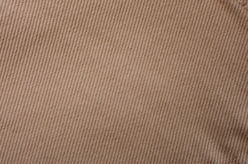 Close-up shot of beige denim texture with stitching.