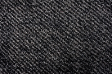 Close-up shot of black denim texture with stitching.