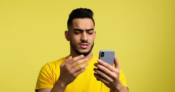 Annoyed upset man looking at his mobile phone with frustration