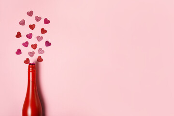 Romantic red bottle with hearts on pink background. Minimal Valentine's day card idea. Flat lay, top view
