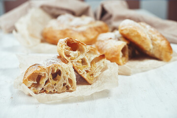 Puff pastry apple filling pie on the table on a light background.