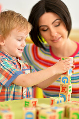 Woman and little boy playing with cubes