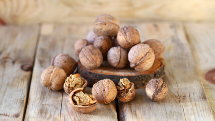 Walnuts in shells on a wooden surface.