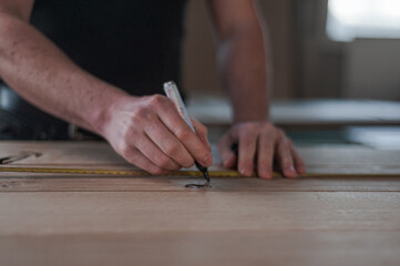 Marking something on a piece of wood.