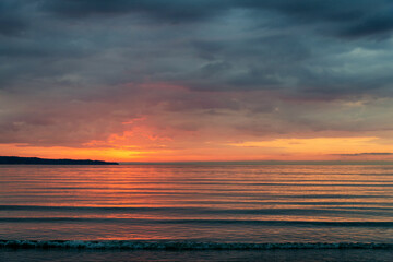 Obraz premium beautiful fiery sunrise on the beach - space for text