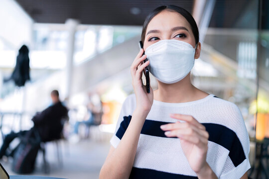 young casual attractive female wear face mask hand gesture say hi to greeting her friend while working with laptop freelance job at cafe outside terrace store,happiness female working outdoor terrace