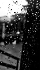 Naklejka na ściany i meble Rain - water drops on window - summer rain - photographic glimpse - rain detail on glass - internal external view - Black and white photography