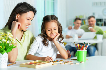Cute little girl with her mother studying