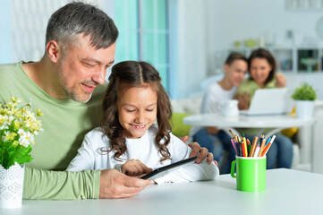 Portrait of a father with little daughter using tablet