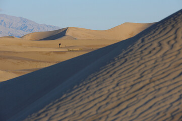Fototapeta na wymiar Photographer pondering shooting the sand dunes at Mesquite Flat, Death Valley National Park, California