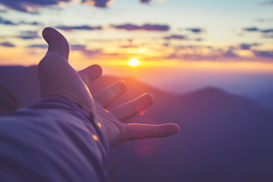 Human hand reaching for the sun, abstract picture of nature hand with sunrise,copy space for text.