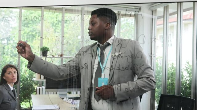 African man explains your business aviation plan on a whiteboard to your supervisor and office colleagues. aviation business concept