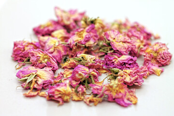 Dry rose buds tea on white background. Selektive focus.