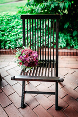 Blumenstrauss auf einem Gartenstuhl aus Holz