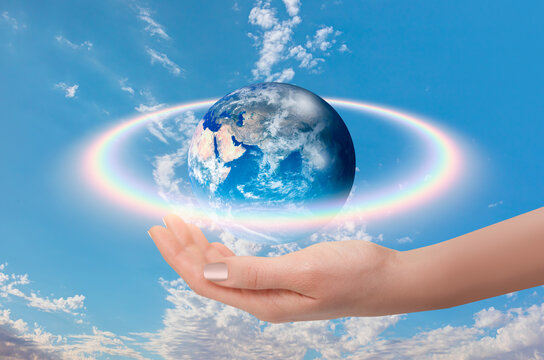 Rainbow surrounds the Planet Earth with woman hand "Elements of this Image Furnished by NASA"