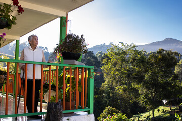 Senior woman at a traditional colorful balcony in the beautiful colonial town of Salento in the region of Quindio in Colombia