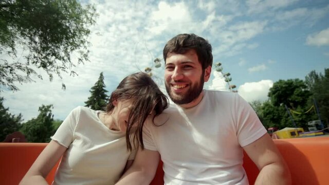 Selfie video of couple riding the roller coaster. Amusement park rides. Extreme riding, laughing and screaming of excitement, adrenalin.