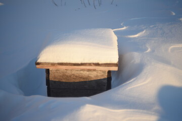 Wooden boxes for flowers under the snow in winter