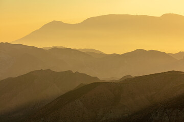 Sunrise in Andalusia: hazy mountains in the he desert of Hoya de Guadix, Spain