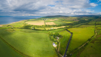 Aerial view of an old cultural landscape with rolling hills, farms and meadows on the Isle of Arran, Scotland
