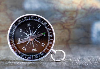 Fototapeta na wymiar Travel planning navigation concept. Classic black magnetic detail of compass on light blue backround