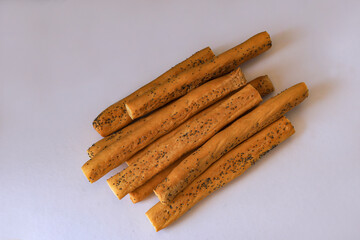 Homemade poppy cheese bread sticks on white background