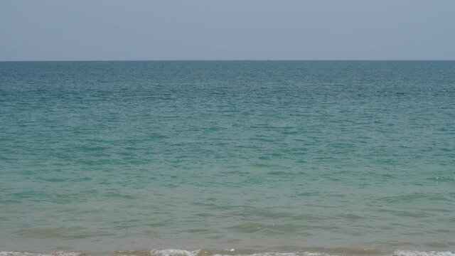 Small ripples on sea surface, blue-green water near tropical island of Thailand. Static view of empty open space, light haze from midday heat seen at horizon line
