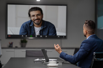 Obraz premium Middle eastern businessman having video chat with employee at office