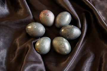 Fototapeta na wymiar photo of eggs painted black lying on a dark background. Easter theme