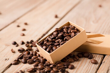 roasted coffee beans in yellow gift box with bow on wooden table