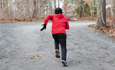 Fototapeta premium Sprinter runner running fast up a small hill on a cold day